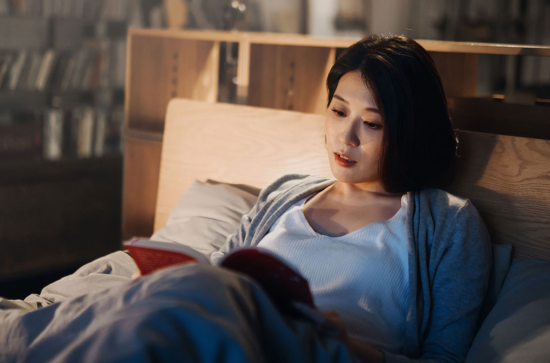 Woman reading in bed relaxing